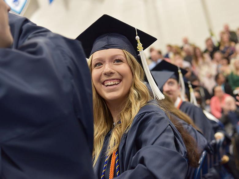 A graduate smiling at the spring 2022 commencement ceremony